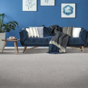 Living room carpet floor with blue sofa | Gillen Water Flooring